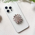 Detailed macro view of a pink and white crystal flower griptok on a white phone - Pink White Rhinestone Flower (Small Pink Diamond - Airbag Stand)