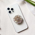 Detailed macro of a luxury floral phone grip with radiant iridescent rhinestones - Rainbow Iridescent Gem (Teardrop Rainbow - Airbag Stand)