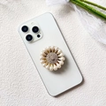 Detailed macro of flower-shaped phone grip with diamonds and white pearls on white phone - White Teardrop Pearl (Teardrop Pearl - Airbag Stand)