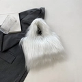 Stylish white faux fur handbag on a grey blazer for a chic minimalist aesthetic look - White