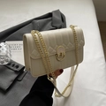 Minimalistische beigefarbene Stepptasche aus Leder mit Goldkette und ovalem Metallverschluss - Cremeweiß