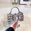 Silver bow-shaped clutch bag with metallic mirror finish and large central gemstone - Silver