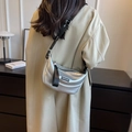 Silver metallic crescent hobo bag with a wide black printed strap shown on model - Silver