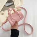 Pink cylinder mini crossbody bag with litchi grain texture and gold hardware details - Pink