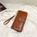 Pochette en cuir ciré marron avec motifs perforés, boucle marguerite et dragonne - Marron