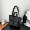 Black quilted puffer tote bag with padded soft texture and dual handles for shoulder carry - Black