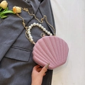 Pink sequin shell clutch bag with pearl handle and golden chain strap on a blazer - Pink
