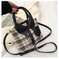 Detailed view of the unique shirt collar design and beige plaid fabric of the handbag - Black