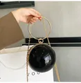 Detail of black spherical evening bag with gold ring handle and metallic chain strap - Black