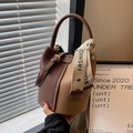 Elegante bolso de hombro tipo cubo en cuero café y tostado con asa decorada con seda - café
