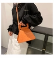 Borsa a trapezio arancione con stampa coccodrillo indossata da una modella in stile minimal - Arancione