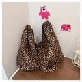 Dettaglio di borsa tote grande con stampa leopardata su superficie di legno - Leopardo Marrone Giallastro