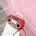 Retro red radio shaped handbag with cream accents and crossbody strap in a pink cart - Red