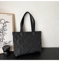 Dettaglio della texture trapuntata nera e della tracolla spessa di questa borsa tote - Nero