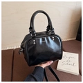 Detail of a vintage black glossy leather Boston bag with LiUU logo and dual handles - Black