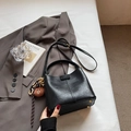 Vintage black bucket bag with plush bear charm and elegant leather texture finish - With Pendant / Black