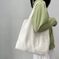 White textured tote bag with leaf embroidery carried by model in casual green outfit - White Leaf Texture