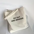 Minimalistische cremefarbene Canvas-Einkaufstasche mit Aufdruck auf weißem Stuhl - Gebrochenes Weiß