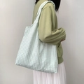 Detailed texture of mint green tote bag with vertical pleated pattern on light fabric - Mint Green