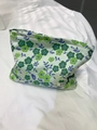 Nahaufnahme der Jacquard-Kosmetiktasche mit Blumenmuster und Etikett auf weißem Stoff - Jacquard Grün
