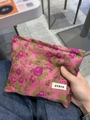 Dettaglio della borsa per cosmetici in jacquard rosa con fiori viola ed etichetta - Rosso rosa con fiori viola