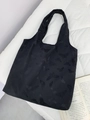 Black tote bag with butterfly embossed texture and spacious minimalist shoulder design - Black