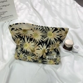 Floral canvas cosmetic bag featuring yellow daisy patterns and secure white zipper closure - Large Daisy Black Makeup Bag
