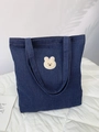 Dettaglio del ricamo a forma di coniglio di peluche beige su borsa tote in denim blu scuro - Coniglio Ricamato / Blu scuro