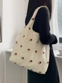 Détail de broderies roses rouges sur sac fourre-tout en toile ivoire avec large bandoulière - Sac Gilet à Broderie Rose