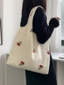 Detail shot of cherry embroidery on a cream canvas tote bag worn by a model - Red Cherry Embroidery (Off-White)