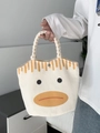 Detail of canvas tote bag showing the woven handle, metal snap button, and cartoon duck print - Beige Braided Handle Duck Expression Style