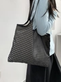 Detailed side view of large checkered canvas tote bag with wide black shoulder straps - Black Plaid
