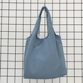 Detail of light blue canvas tote bag with wide integrated handle on a metal rack - Gray Blue
