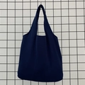 Detail of heavy navy canvas tote bag with integrated handles on a metal grid display - Navy Blue