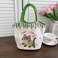Detail of canvas bucket bag with cartoon cat print and green braided rope handle - Happy Kitten