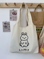 Detailansicht der cremefarbenen Canvas-Tasche mit lebhaftem Hasen-Print an einem Wandhaken - Hasen-Druck (Lively)