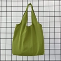 Detail of a grass green canvas tote bag featuring premium woven fabric texture - Grass Green