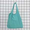 Detail of teal cotton tote bag showing sturdy seamless handles and canvas fabric texture - Lake Blue