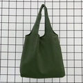 Close-up of deep green canvas tote bag texture hanging on black metal grid - Army Green