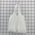 Close-up of white canvas tote bag showing fine woven fabric texture and wide handle - White