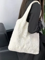 Gros plan de la broderie tournesol sur un sac cabas en toile ivoire porté à la main - Sac Gilet à Broderie Tournesol