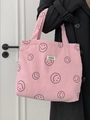 Pink corduroy tote bag with smile pattern and ATRYG label held by a model - Pink