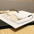 Lunettes de soleil géométriques sans monture, verres teintés orange et pont doré - Thé Transparent