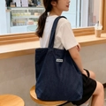 Detail der dunkelblauen Denim-Tragetasche mit weißem Aufnäher und Schultergurt-Design - Schwarz (ATRYG Schwarze Denim-Schultertasche)