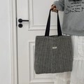 Detail view of large herringbone wool tote bag with black woven handles and logo - Woolen Stripe Black