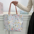 Detailed close-up of a floral embroidered canvas bucket bag with a woven handle and silver snap button - Multi-color Rope Floral / Light Blue