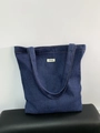Große dunkelblaue Denim-Tragetasche mit ATRYG-Label und Kontrastnähten auf schwarzer Bank - Dunkelblau (ATRYG Dunkelblaue Denim-Schultertasche)