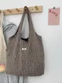 Detail of wool-like stripe tote bag with ATRYG label on home wall hanger - Dark Brown