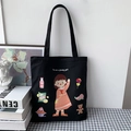 Detail of a black canvas tote bag featuring a cute cartoon girl and snacks illustration - Black (You are a pretty girl!)