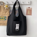Détail du sac cabas en toile noire avec imprimé chat mignon et une poche avant pratique - Noir